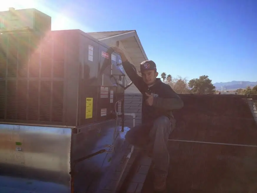 HVAC technician performing Heat Pump Repair on a rooftop unit in Midwest City